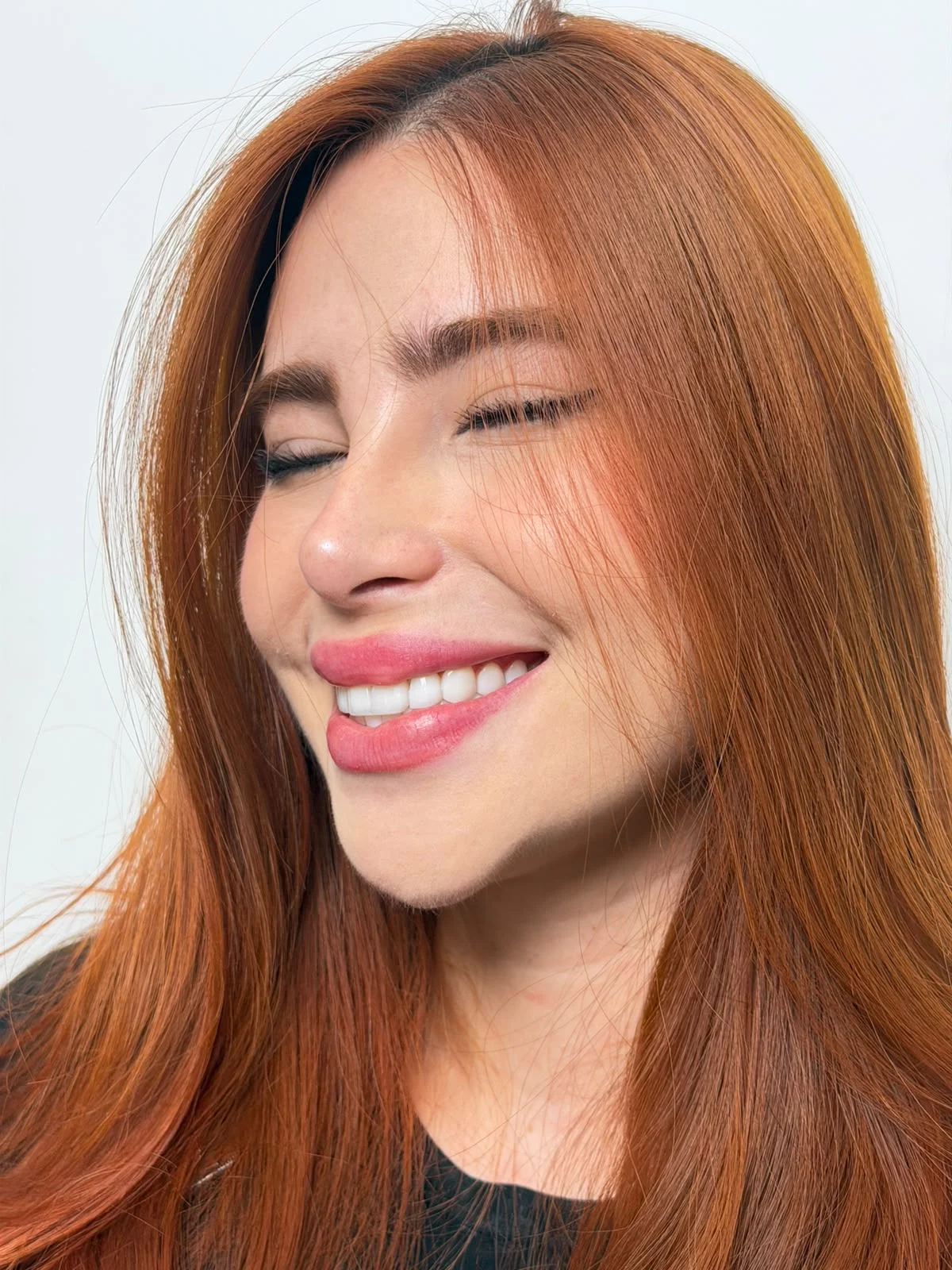 Primer plano de la sonrisa de una mujer de cabello cobrizo